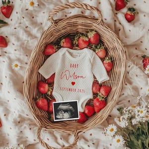 May include: A wicker basket brimming with ripe strawberries and a white baby bodysuit. The bodysuit features the text "Baby Wilson" and "September 2025" in red. An ultrasound scan is also in the basket, surrounded by daisies.