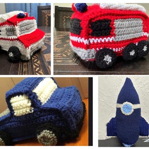 May include: A collection of four crocheted toys including a white and red ambulance with AMR text, a red fire truck, a blue pickup truck, and a dark blue rocket ship. Each item is crafted with yarn and features distinct colors and shapes representing vehicles.