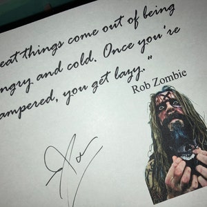 May include: A white card with a black handwritten quote by Rob Zombie, "Great things come out of being hungry and cold. Once you're pampered, you get lazy." A black and white photo of Rob Zombie is in the bottom right corner.