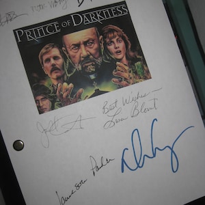 May include: A white page with black and blue signatures. The page has the title "Prince of Darkness" and a photo of three people. The signatures include "Best Wishes Lisa Blount", "James Caan", "Kathy", "with Wong", "D.Frawley".