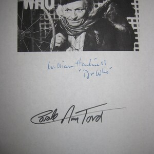 Könnte beinhalten: Schwarzweißfoto von William Hartnell, dem ersten Doktor aus der britischen Science-Fiction-Fernsehserie Doctor Who, mit dem Titelbild der Serie im Hintergrund. Das Foto ist von William Hartnell und Carole Ann Ford signiert, die seine Begleiterin Susan Foreman spielte.