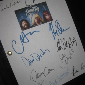 May include: A white sheet of paper with black and blue signatures from the band Spinal Tap. The signatures include the names "Derek Smalls", "Nigel Tufnel", "David St. Hubbins", "Dancen", "Bud Wildwood", and "Gary  Guitar  Pullin". The paper has a small photo of the band with the text "This is Spinal Tap" at the top.