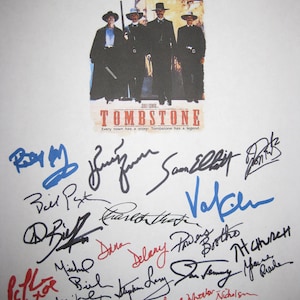 以下が含まれることがあります： 「トゥームストーン」というタイトルと「Every town has a story. Tombstone has a legend.」というキャッチフレーズが書かれた白いポスター。ポスターには、カウボーイハットとカウボーイの服装をした男性グループが描かれている。ポスターには、カート・ラッセル、ヴァル・キルマーなど、映画の俳優たちのサインが書かれている。