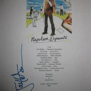 May include: A printed page featuring the movie poster for "Napoleon Dynamite." The poster shows a man in a brown suit with the text "HE'S OUT TO PROVE HE'S GOT NOTHING TO PROVE." Below the poster is the movie title and cast list.