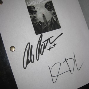 May include: A black and white photo of two men in uniform, with the text "The Lighthouse" above them. The photo is signed by both actors, Willem Dafoe and Robert Pattinson.