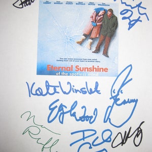 Puede incluir: Un póster blanco con el título "Eternal Sunshine of the Spotless Mind" y firmas del reparto, incluyendo Jim Carrey, Kate Winslet, Kirsten Dunst, Mark Ruffalo, Elijah Wood y Tom Wilkinson.