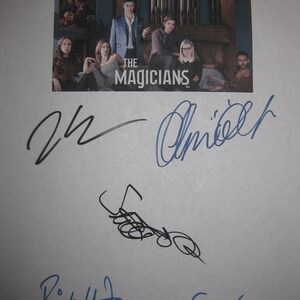 May include: A white sheet of paper with signatures from the cast of the TV show "The Magicians". The signatures are in black and blue ink. The show's logo is visible in the background.
