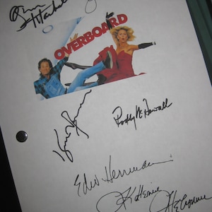 May include: A white sheet of paper with black ink signatures from the cast of the movie "Overboard". The signatures include Goldie Hawn, Kurt Russell,  Roddy McDowall,  Edw.  Hennicke,  and  Katherine Helmond. The movie poster is in the background.