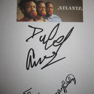 以下が含まれることがあります： 白い紙に黒い署名が3つ書かれている。一番上の署名は「Donald Glover」となっている。左下の署名は単純な「&」記号である。右下の署名は「Brian Tyree Henry」となっている。署名の上には、茶色の背景に白い文字で「ATLANTA」と書かれた写真が3人の男性が写っている。