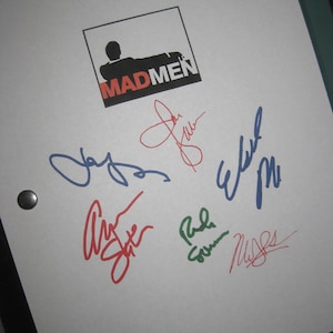 May include: A white sheet of paper with the Mad Men logo and five signatures in different colors. The signatures are in blue, red, and green ink.