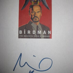 Könnte beinhalten: Ein roter Poster mit einer Schwarzweißillustration eines Mannes mit einem Vogel auf dem Kopf. Der Poster lautet "Birdman oder (Die unerwartete Tugend der Ignoranz)" und ist von Michael Keaton signiert.