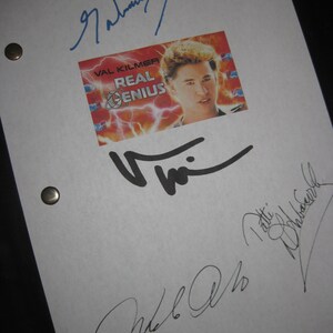 May include: A white page with three signatures. The top signature is in blue ink and says "Daniel Stern". The middle signature is in black ink and says "Val Kilmer". The bottom signature is in black ink and says "Meg Ryan". There is a small image of Val Kilmer from the movie "Real Genius" with the title of the movie printed below the image.