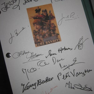 May include: A white sheet with multiple signatures in black ink and one in red ink. A small, rectangular image in the center features the movie title "Time Bandits" and character illustrations. The signatures appear to be autographs.