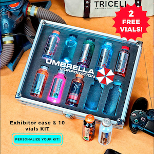 Puede incluir: Una vitrina con diez viales de líquidos de colores, etiquetados como "Umbrella Corporation" y "Tricell". La caja tiene marco plateado e incluye un logotipo de paraguas rojo y blanco. El texto "2 FREE VIALS!" es visible.