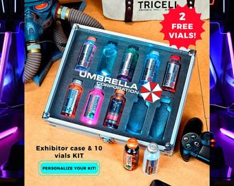 May include: A display case containing ten vials of various colored liquids, labeled "Umbrella Corporation" and "Tricell". The case is silver-framed and includes a red and white umbrella logo. The text "2 FREE VIALS!" is visible.