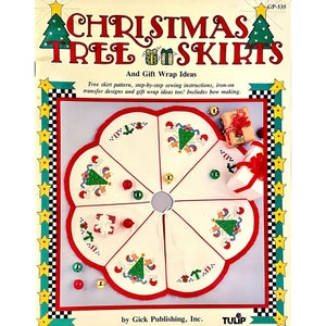 Op de afbeelding: Een witte kerstboomrok met rode bies en een rode strik. De rok is verdeeld in zes secties, elk met een ander geborduurd ontwerp van een kerstboom met ornamenten en cadeaus. De tekst "Christmas Tree Skirts" en "And Gift Wrap Ideas" staat gedrukt op de omslag van het boekje. De tekst "GP-535" staat gedrukt in de rechterbovenhoek van de omslag. De tekst "by Gick Publishing, Inc." staat gedrukt onderaan de omslag. De tekst "TULIP" staat gedrukt op een rood-wit lint in de rechterbenedenhoek van de omslag.