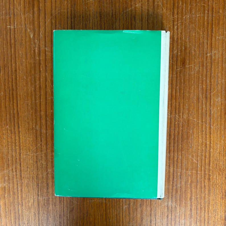 May include: A closed book with a bright green cover and white pages. The book is rectangular and has a clean, minimalist design. The cover is a solid, vibrant green color.