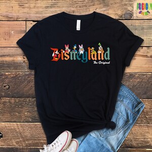 Puede incluir: Una camiseta negra con un gr&aacute;fico colorido de Mickey Mouse y sus amigos delante del texto "Disneyland The Original".