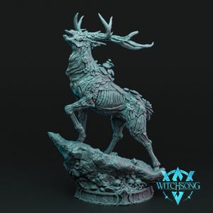 May include: A detailed sculpture of a stag with exposed rib cage and floral accents, standing on a rocky base. The sculpture is a light teal color and features intricate details, including antlers and a base with skulls. The Witchsong logo is visible.