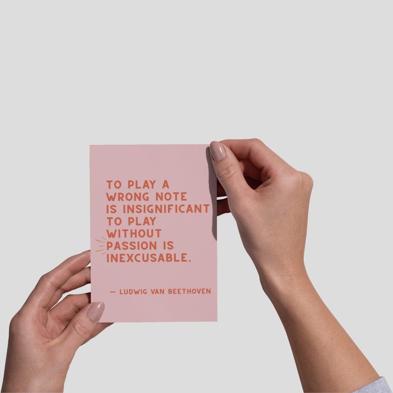 K&ouml;nnte beinhalten: Eine rosa Karte mit einem Zitat von Ludwig van Beethoven, das lautet: "Einen falschen Ton zu spielen ist unbedeutend. Ohne Leidenschaft zu spielen ist unverzeihlich."