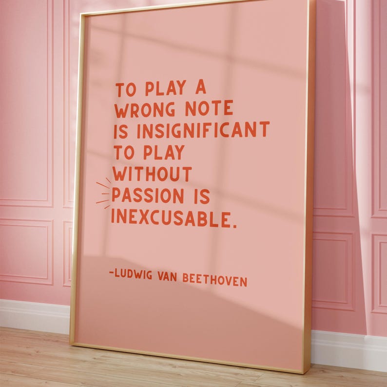 K&ouml;nnte beinhalten: Ein rosa Poster mit goldenem Rahmen, auf dem ein Zitat von Ludwig van Beethoven steht: "Einen falschen Ton zu spielen ist unbedeutend. Ohne Leidenschaft zu spielen ist unverzeihlich."