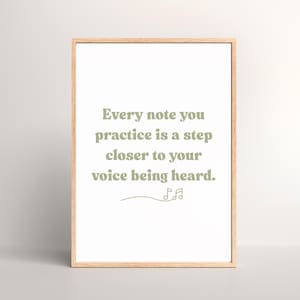Op de afbeelding: Een ingelijst print met een motiverende quote in groene tekst: "Elke noot die je oefent is een stap dichterbij dat je stem gehoord wordt." De quote wordt gevolgd door een gestileerd muzieknotensymbool.
