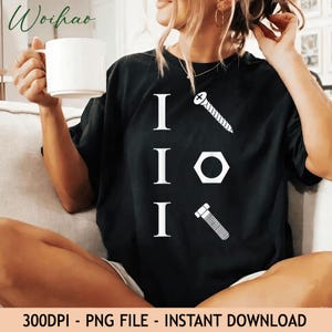 Puede incluir: Una camiseta negra con un diseño gráfico blanco que presenta tres letras I mayúsculas verticales. Cada letra se combina con un icono de ferretería: un tornillo, una tuerca hexagonal y un perno, dispuestos en columna para crear un juego visual.