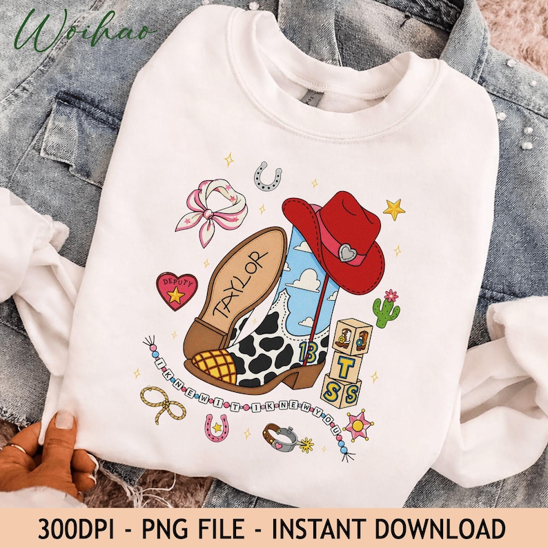 May include: A white crewneck sweatshirt featuring a graphic print of a cowboy boot with a cow print pattern, a red cowboy hat, a pink bandana, a cactus, and wooden blocks. The text "TAYLOR" is on the boot, and "I KNEW IT I KNEW YOU" is printed.