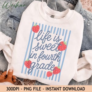 Può includere: Una felpa bianca a girocollo con un design grafico a strisce verticali azzurre. Il testo "life is sweet in fourth grade" è stampato in corsivo blu, circondato da cinque fragole rosse con piccioli verdi e puntini bianchi.