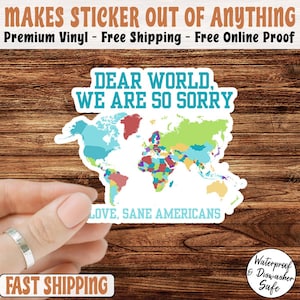 May include: A white sticker with a colorful world map design. The sticker has the text "DEAR WORLD, WE ARE SO SORRY" and "LOVE, SANE AMERICANS". The sticker is waterproof and dishwasher safe.