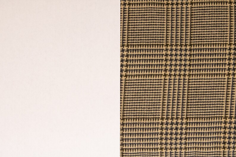 Puede incluir: Primer plano de una tela de cuadros marrones y beige con fondo blanco.