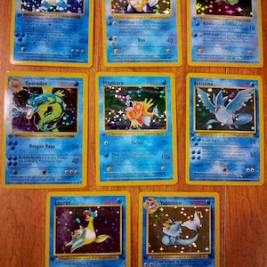 May include: A collection of eight holographic Pokemon trading cards arranged in three rows. The cards feature Blastoise, Wartortle, Squirtle, Gyarados, Magikarp, Articuno, Lapras, and Vaporeon, each displaying character illustrations, HP values, and text.