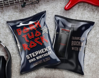 Op de afbeelding: Twee zwarte chipzakken met een rock-'n-roll thema. Eén zak zegt "Born Two Rock" met een rode ster en een gitaar afbeelding. De andere zak zegt "Bedankt voor het rocken met ons". Beide zakken hebben een zwart-witte gitaar afbeelding. De tekst op de zakken is wit.