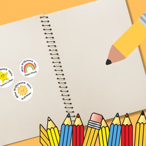 May include: Three round teacher reward stickers with a yellow star, rainbow, and sun. Each sticker says "Miss Wilkinson says" with a different phrase: "You're a Star", "Super Work", and "Well Done". A notebook with a spiral binding and a yellow pencil with a red eraser are in the background.