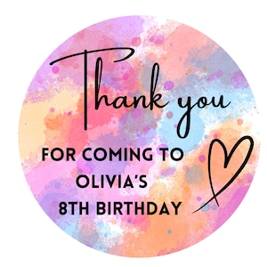 May include: Round thank you sticker with a watercolour background in shades of pink, orange, blue, and purple. The sticker says "Thank you for coming to Olivia's 8th Birthday" with a heart drawn next to the text.