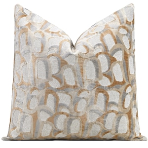May include: A decorative throw pillow with a geometric pattern in shades of beige and gray.