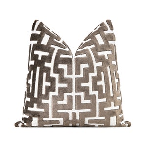 May include: A brown and white geometric patterned throw pillow with a square shape.