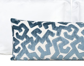 May include: A blue and white patterned lumbar pillow with a geometric design. The pillow is made of a soft, plush fabric.