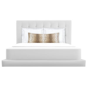 May include: A white upholstered bed with a tufted headboard and a white duvet. A brown and black patterned pillow is on top of the white pillows.