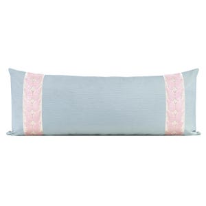 May include: A long rectangular bolster pillow in a solid light blue color. The pillow features two vertical bands of cream-colored fabric, each embroidered with a repeating pattern of light pink butterflies, positioned near the left and right ends.