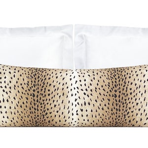 May include: Two white standard pillowcases and a brown and black patterned lumbar pillow. The lumbar pillow has a cheetah print pattern.