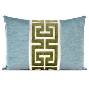 May include: A rectangular decorative pillow with a light blue textured background and a central vertical panel. The panel features a geometric design in olive green on a white background. The pillow is designed for home decor.