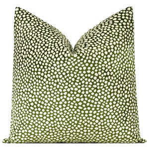 May include: Green velvet pillow with a white polka dot pattern.