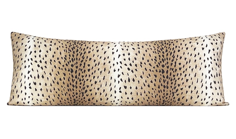 May include: A long, rectangular throw pillow with a brown and black cheetah print pattern.