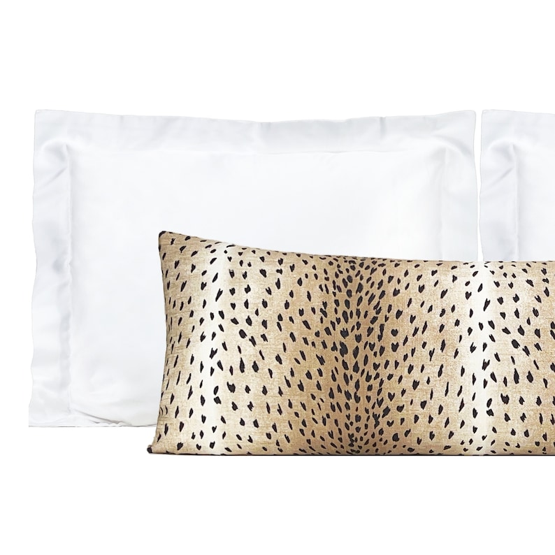 May include: A brown and white patterned lumbar pillow with a white standard pillow behind it.