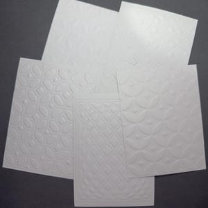 10 szt. tłoczonego, białego kartonu o gramaturze 300 g/m2 - symetryczne, powtarzające się wzory geometryczne - do ręcznie robionych kartek i albumów