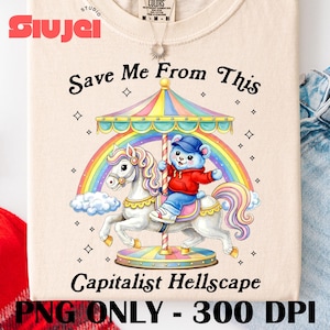 May include: Beige t-shirt featuring a carousel design with a bear riding a horse under a rainbow. The text "Save Me From This Capitalist Hellscape" is printed below the carousel image. The shirt has a crew neck and short sleeves.