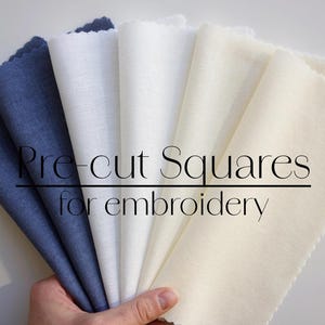 May include: Five pre-cut fabric squares for embroidery. Two are white, two are off-white, and one is a dark blue.