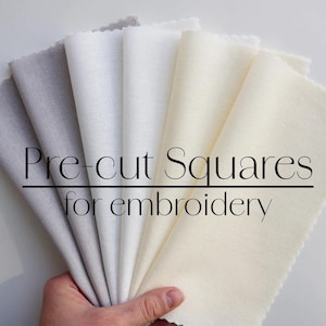 May include: A collection of pre-cut fabric squares in various shades of white and gray, perfect for embroidery projects. The squares are arranged in a fan shape and the text "Pre-cut Squares for embroidery" is visible.