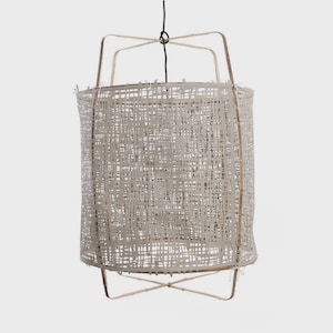 May include: A cylindrical pendant light fixture featuring a light beige, open-weave fabric shade. The shade is supported by a light-colored wooden frame with a cross-brace design at the bottom and a top structure that connects to a single black cord.
